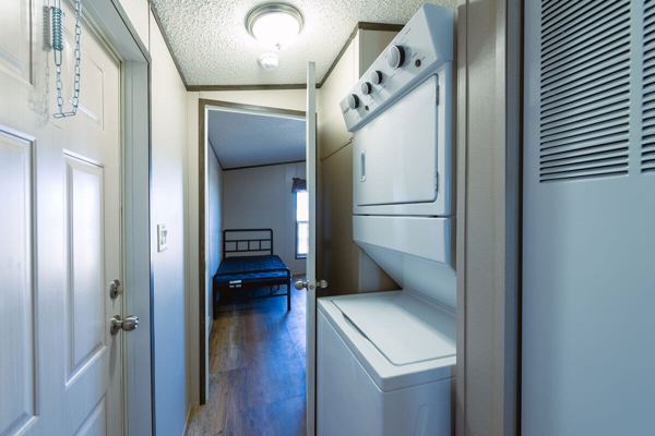 Hallway with stacked washer and dryer